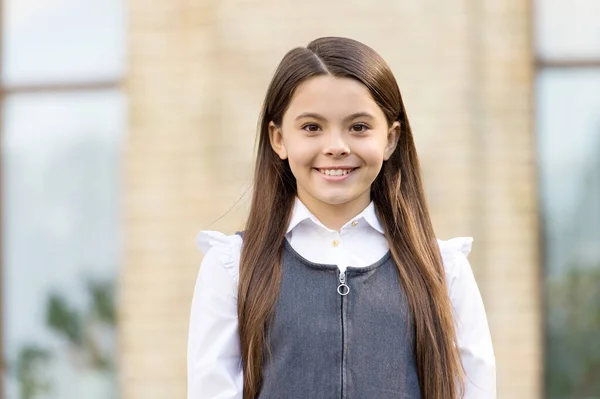 Dê um grande aplauso para o novo ano letivo. Feliz estudante ao ar livre. Uma colegial de volta à escola. Pequena estudante usar uniforme. Educação formal. Ensino privado. 1 de Setembro. Dia do conhecimento — Fotografia de Stock