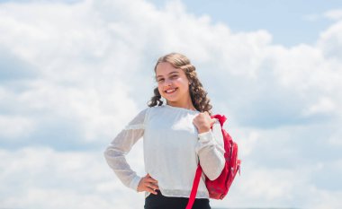 Açık hava dersleri. Başarılı bir öğrenci. Çalışmak için iyi bir gün. Bedava eğitim. Okul çantalı, gökyüzü geçmişli mutlu bir kız. Okula dönelim. Okula giderken gülümseyen küçük bir çocuk. Bilgi günü