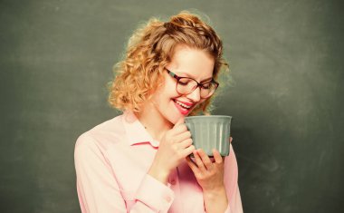 Okul pedagogu için ilham verici bir içki. Kahve bağımlısı. Vücudunu ve zihnini şarj et. Bir doz kafein. Öğretmen arka planda kahve içiyor. Kadınlar kahveyi sever. Tüm gün boyunca enerji harcaması