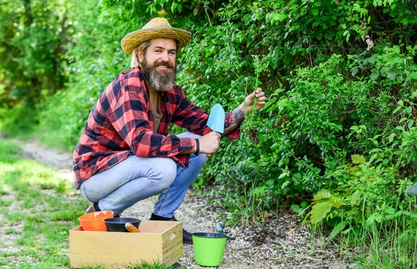 Fazenda orgânica. Trabalhar num jardim. jardineiro homem maduro. Solo para cavar espátulas. Ferramentas de jardim. sementes e solo. Primavera no jardim. Fazendeiro que dá fertilizante. O jardineiro está cavando no jardim — Fotografia de Stock