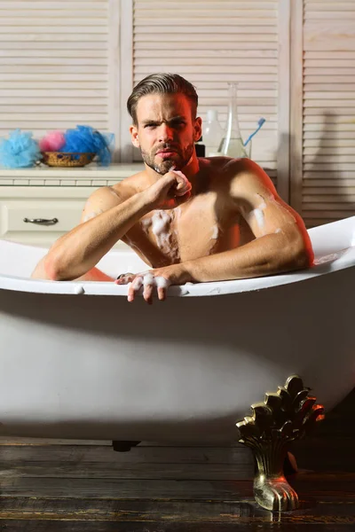 Hombre con cara estricta con puño bajo barbilla tomando baño —  Fotos de Stock