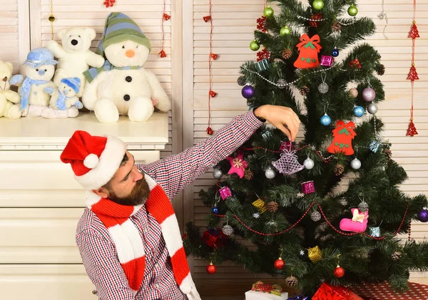 Jultomten med intresserad ansikte nära byrå och julgran — Stockfoto