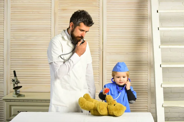 El veterinario y el ayudante examinan al oso de peluche. Padre e hijo — Foto de Stock