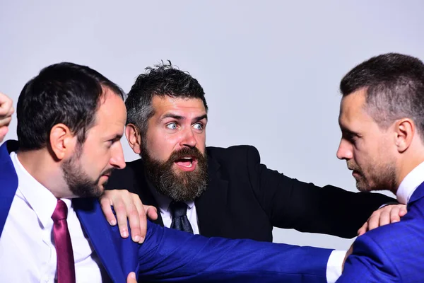 Resmi giyinmiş katı ve korkmuş yüzlü iş adamları.