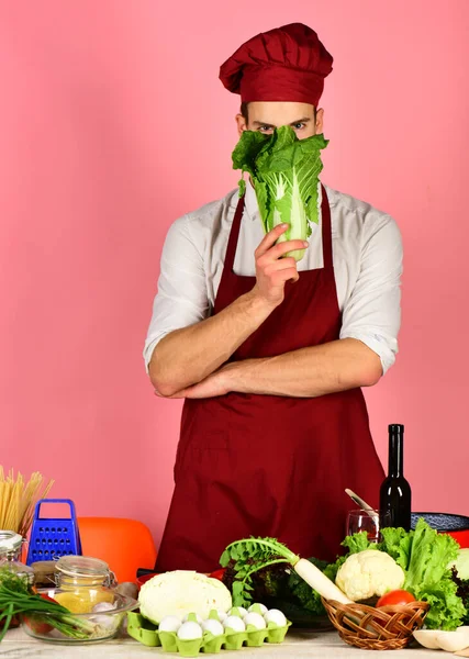 Chef con la cara oculta sostiene racimo de lechuga en rosa — Foto de Stock