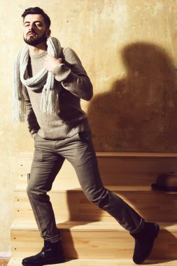 Duvarın arkasında ciddi bir yüzü olan sakallı bir adam.