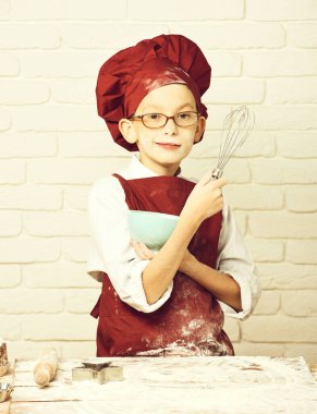 Beyaz tuğla duvarda lekeli aşçı çocuk.