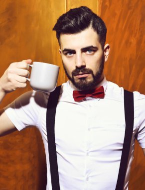 Elinde çay tutan sakallı adam, ciddi yüzlü kahve.