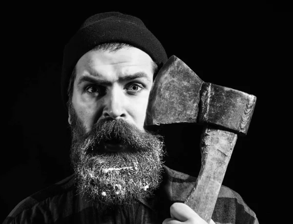 Scared man with axe on black background