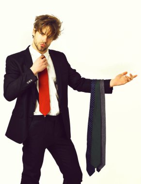 Sakallı, maço, şık takım elbiseli, kravatlı bir adam.