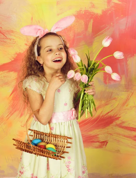 带着彩蛋和郁金香花的快乐的东方女孩 — 图库照片