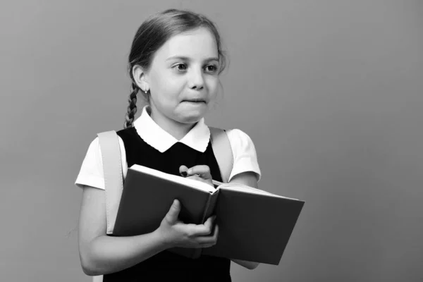 Girl writes in big blue notebook. Pupil in school uniform — Stock Photo, Image