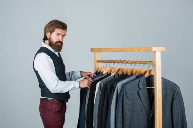 Yeni fikirleri paylaşıyoruz. Klasik kostüm giymiş yakışıklı sakallı moda adamı. Özel dikim takım elbiseli bir adam pahalı bir smokin giyiyor. Butikte bir adam. Takım elbiseli adam. atölyedeki terzi