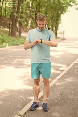 Spor saati. Adam dışarıda spor yapıyor. Spor giyim modası. Sağlık ve zindelik. Sporcu enerji dolu. Sporcu sportif aktiviteler yapıyor. Spor saatiyle izleme eğitimi. fitness bilekliği