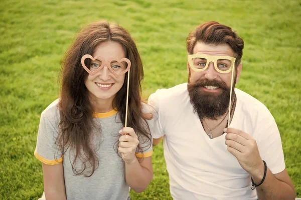 Summer vacation. Emotional couple radiating happiness. Happy together. Couple in love cheerful youth booth props. Love story. Couple relaxing green lawn. Man bearded hipster and pretty woman in love