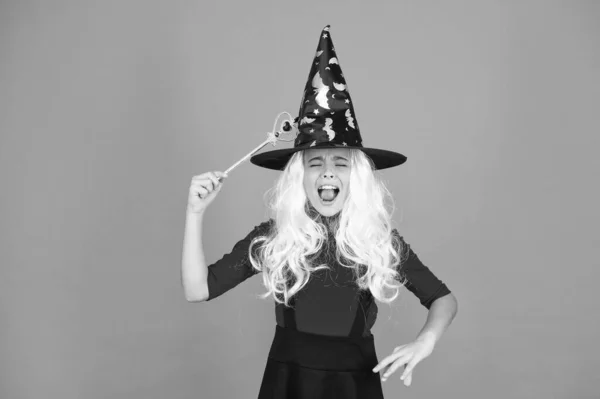 Varázslat. Boszorkányjelmezes kisgyerek. Halloween buli. Egy kislány fekete boszorkány kalapban. Őszi szünet. Csatlakozz az ünnepléshez. Varázslat. Kis boszi ősz hajjal. Varázsló varázspálcával — Stock Fotó