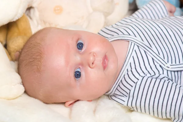 Bebé con ojos azules y cara abierta sobre fondo de manta — Foto de Stock