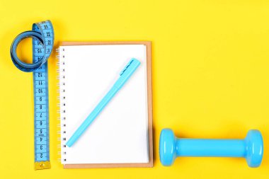 Cyan mavisi spor aletleri. Not defteri, kalem ve spor salonu.