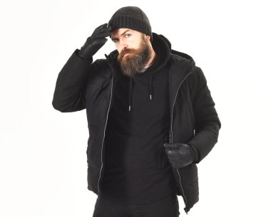 Sakallı ve bıyıklı maço kışlık ceket ve şapka giyiyor.