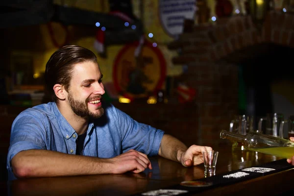 Homem com barba senta-se no balcão de bar no fundo borrado . — Fotografia de Stock