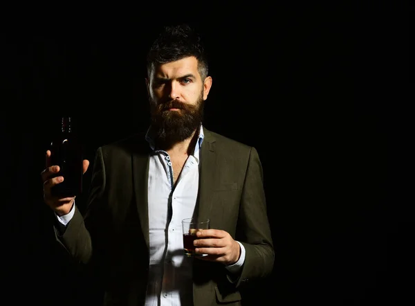 Мужчина с бокалом виски или бурбоном и бутылкой — стоковое фото