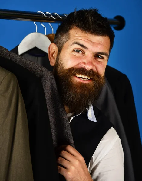 Άντρας με γενειάδα στο ράφι ρούχων. Βοηθός καταστήματος ή πωλητής — Φωτογραφία Αρχείου