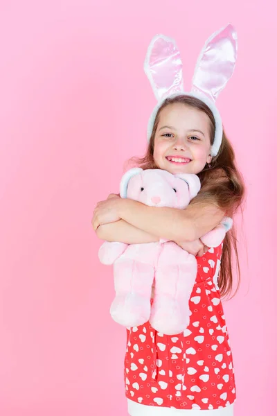 Niñez, juventud y crecimiento Chica feliz abrazando juguete de conejo sobre fondo rosa. — Foto de Stock
