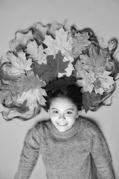 Höstlöven faller ner. Glad flicka bär färgglada blad i långt hår. Skapa frisyr med höstlöv. Ha kul med fallna löv. Skönhetssalong. Frisör — Stockfoto