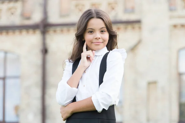 Ett listigt ansikte. Leende elev. Ha det så kul. Glad unge som kopplar av utomhus. Glada skolflicka. Skolflickan slappnar av. Glad barndomsidé. Internationella barnens dag. Privatundervisning. Fritid och vila — Stockfoto