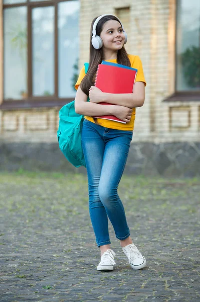 A educação traz oportunidades. menina no fone de ouvido ouvir música. obter conhecimento de ebook. educação escolar moderna. de volta à escola. adolescente feliz levar caderno de trabalho. criança sorrindo segurar pastas. felicidade infantil — Fotografia de Stock