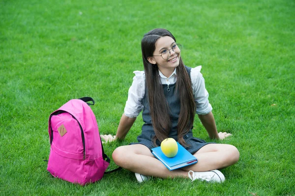 The best time to take break. Happy child relax on green grass. School break. Snack break. Healthy eating and snacking. Vegetarian food. Nutrition education. Healthy body eats healthy food