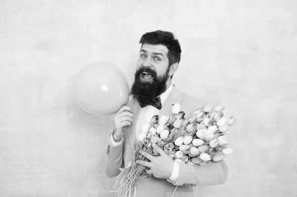 Gift bouquet. Present for spouse. Guy with air balloon. Birthday party. Bearded man hipster with flower bouquet. 8 march. Flowers for womens day. Bearded man with tulips. Spring mood. Love date — Stock Photo, Image