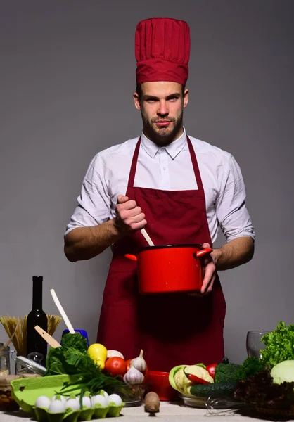 Professionelles Küchenkonzept. Chef in weinroter Uniform bereitet Mahlzeit zu. — Stockfoto