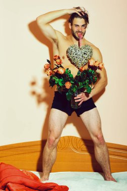 Sakallı, maço, gül desenli, dişlerinde sevgililer günü kalbi olan bir adam.