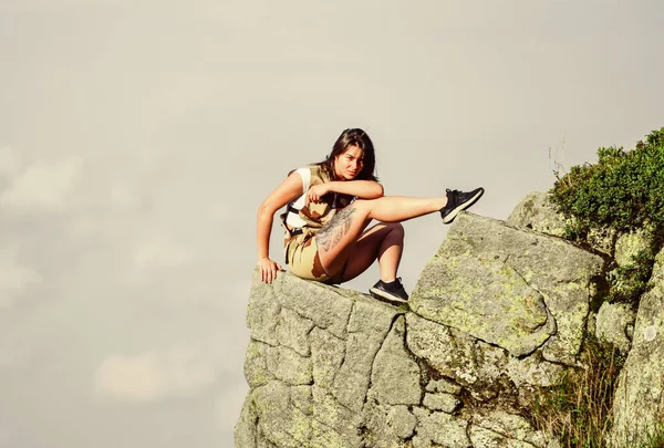 En el borde del mundo. Mujer sentada en el borde del acantilado en las altas montañas fondo cielo azul. Senderismo momento de paz. Disfruta de la vista. Concepto extremo. Caminante turístico chica relajante borde acantilado. Relajación peligrosa —  Fotos de Stock