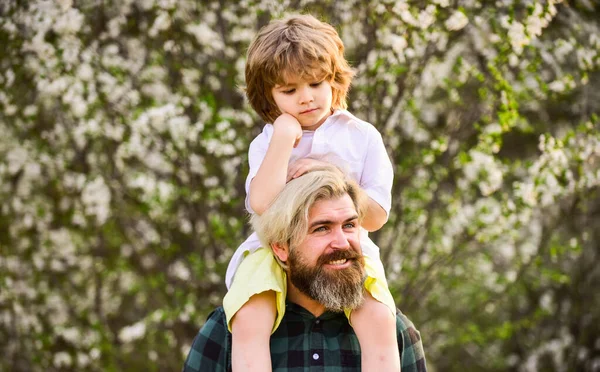 Pappa och son. Min lille son. Vårpromenad. Faderskap. Lycklig familj. Pappadagen. Liten pojke och far i naturen bakgrund. Hipster och lille son i blommande trädgård. Skäggig brutal man, god far — Stockfoto