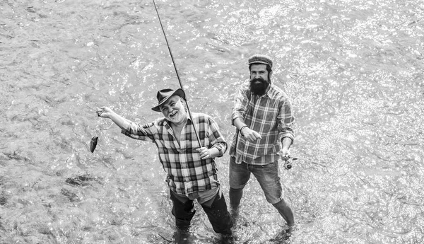 together we can do so much. father and son fishing. male friendship. family bonding. summer weekend. mature men fisher. two happy fisherman with fishing rod. hobby and sport activity. Trout bait