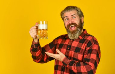 Alkol bağımlılığı. Rahatlamış yakışıklı adam nefis birasını yudumluyor. Barda bir bardak biranın tadını çıkarıyor. Taze soğuk bira bekliyor. Sıkı çalışma gününden sonra. Bar tezgahında bira içeriz.