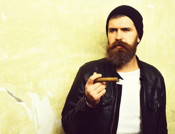 Bearded brutal caucasian hipster smoking cigar