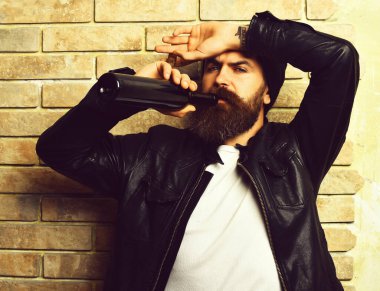 Sakallı, Kafkas hippisi elinde şişe, puro içiyor.