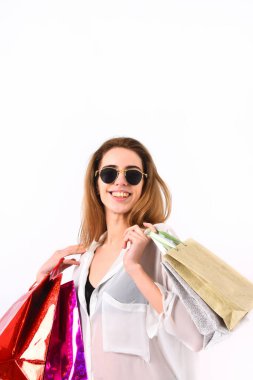 Güneş gözlüklü, mutlu yüzlü, beyaz arka planda yalnız bir kız..