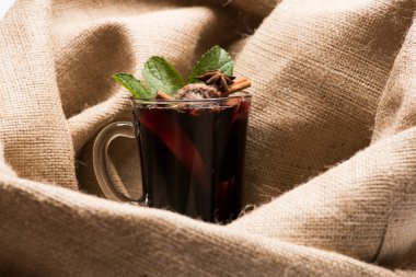 Arka planda çuval bezi olan bir kadeh kırmızı şarap..