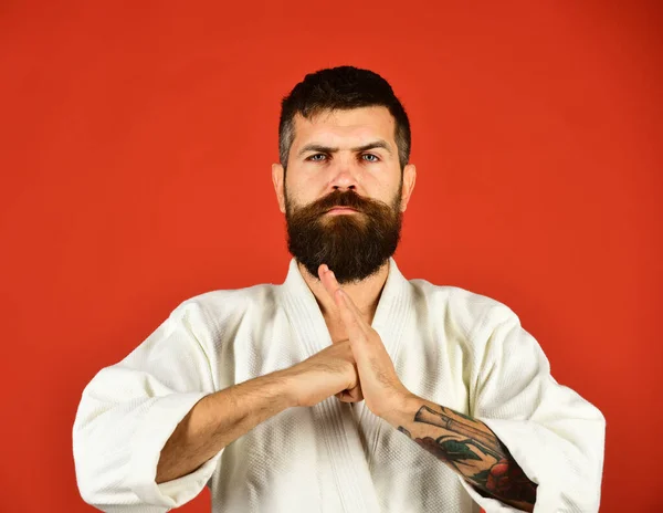 Karate man with confident face in uniform. Man with beard