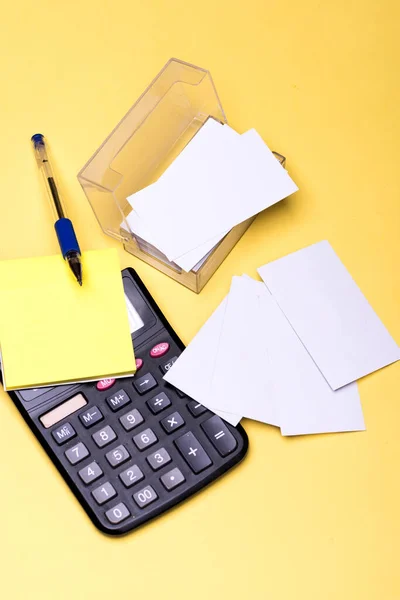 Schrijfgerei en rekenmachine. Papieren met gele notitie, rekenmachine en kaarten — Stockfoto