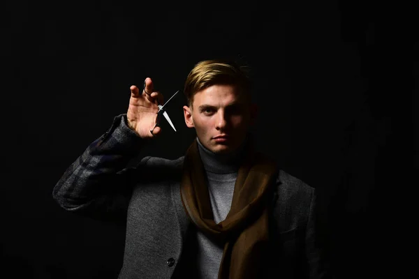 Man in vintage style holds steel scissors. Macho in suit