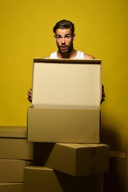 Şaşkın suratlı maço beyaz tişört giyiyor..