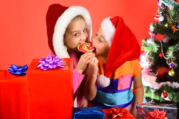 Niños en sombreros de Navidad con cajas y árbol de Año Nuevo. —  Fotos de Stock