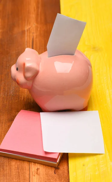 Moneybox for coins with pig face and white card inside