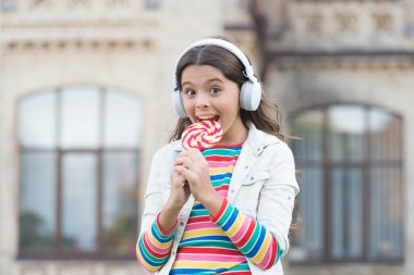 Kız kablosuz kulaklıklar lolipop şekeri, iştah konsepti yer.
