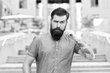 Sakallı adam. Kendine güveni tam vahşi bir adam caddede yürüyor. Erkek berber bakımı. Erkek modası. Sakallı ve bıyıklı adam. Berber salonu. Sokak tarzı. Sokakta yürürken. Merdivenlerde sakallı, olgun bir hippi.